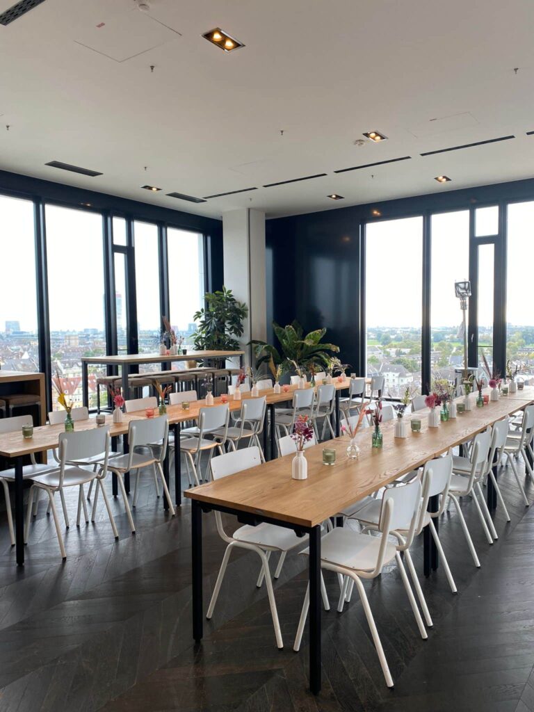 A long table at an event venue with floor-to-ceiling windows