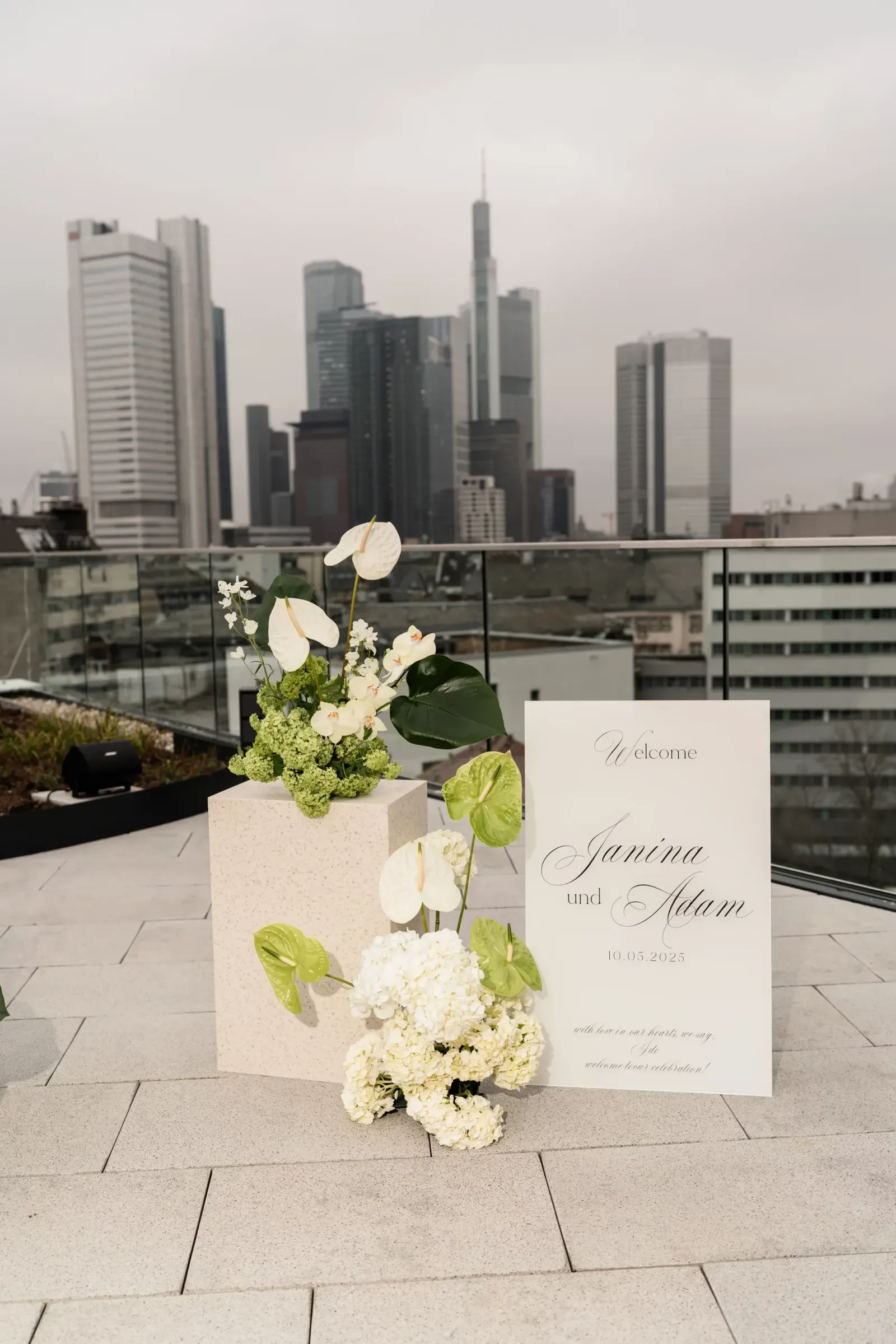 Floral decorations and a welcome sign on a rooftop terrace in Frankfurt