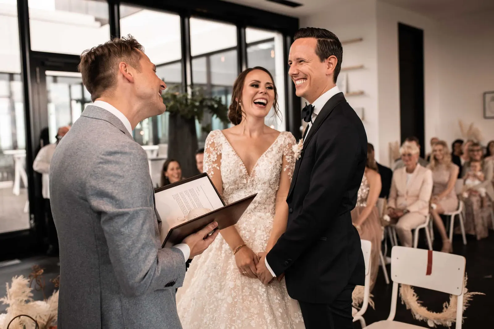 The bride and groom laughing during their outdoor wedding ceremony in Düsseldorf