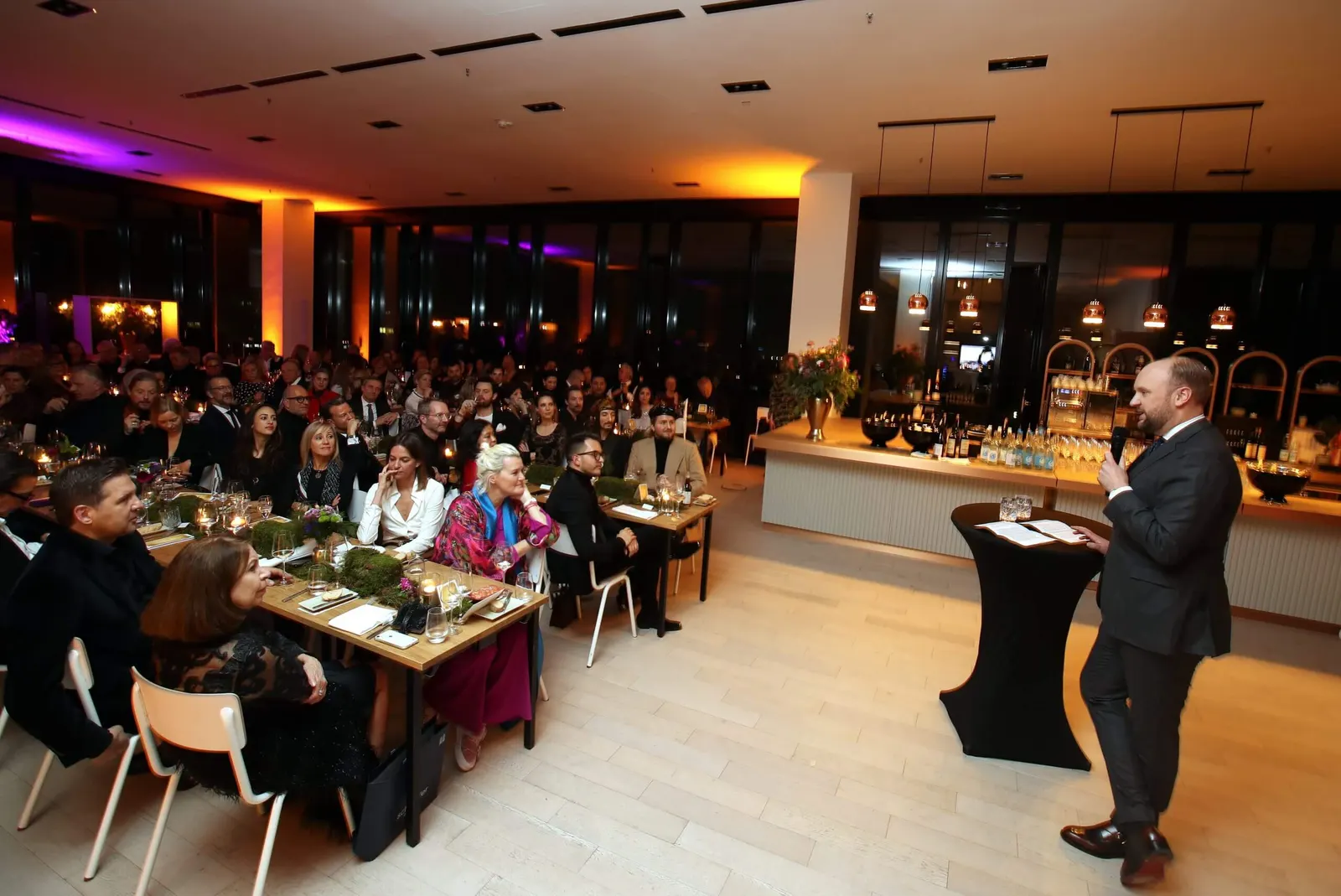 Guests seated at tables during an evening event in Düsseldorf