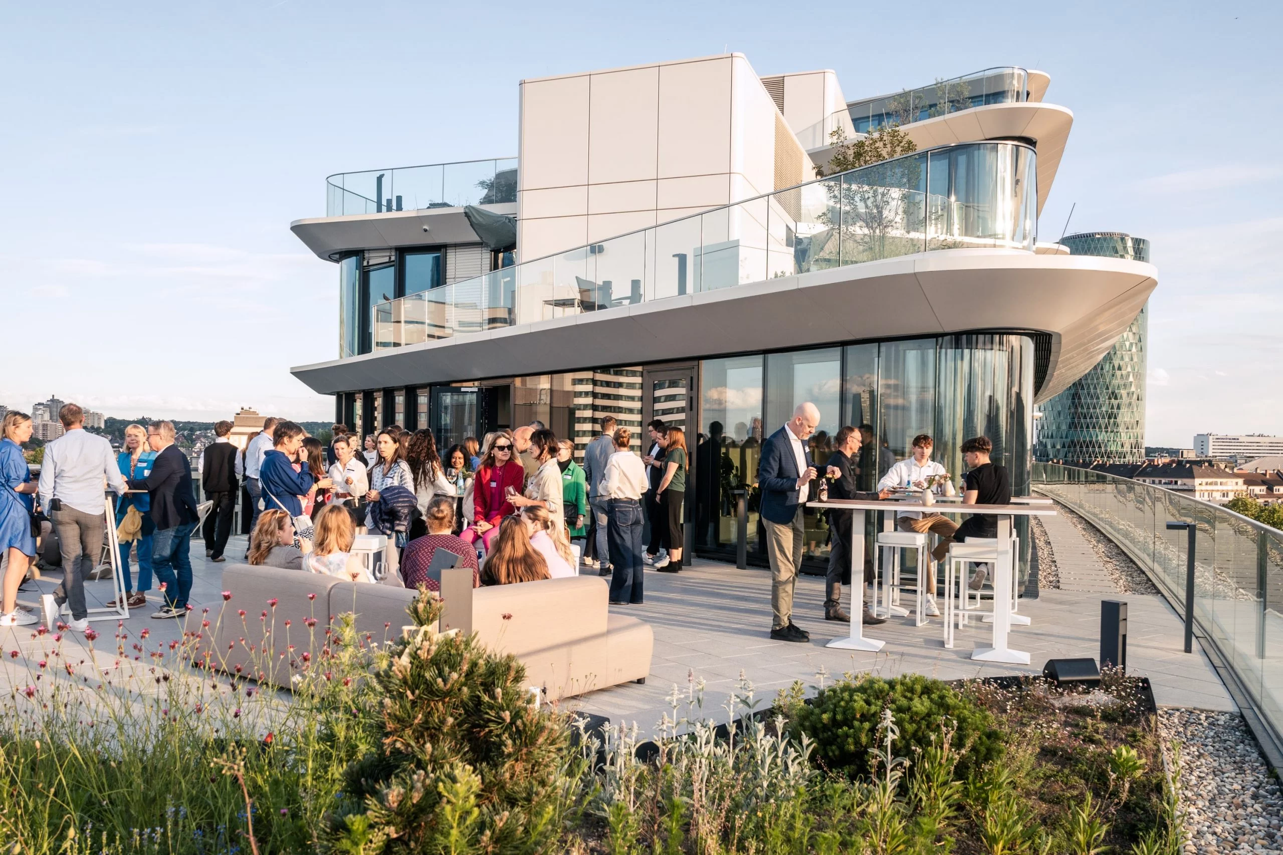 Gäste auf einer Rooftop-Terrasse bei einem Abendevent